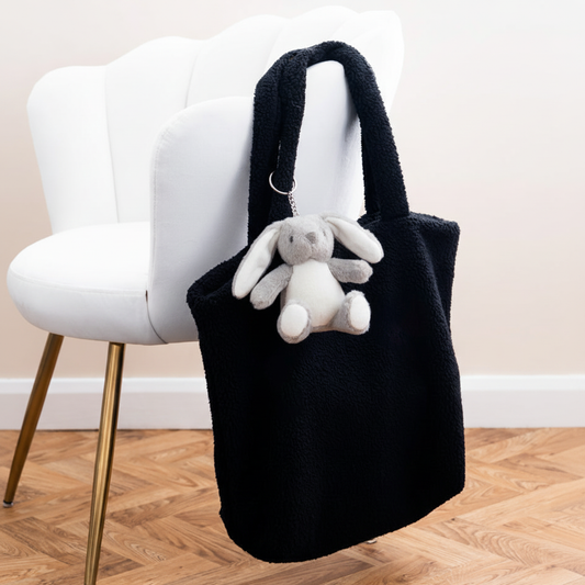 Mumbles Bear Keyring #2 on black fleece shopper with white velvet chair