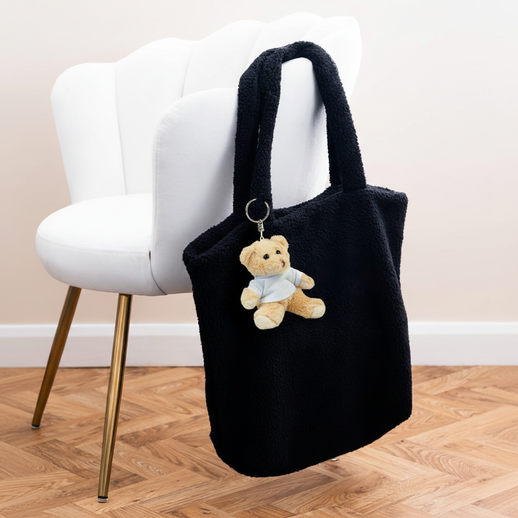 Mumbles Bear Keyring on black fleece shopper with white velvet chair