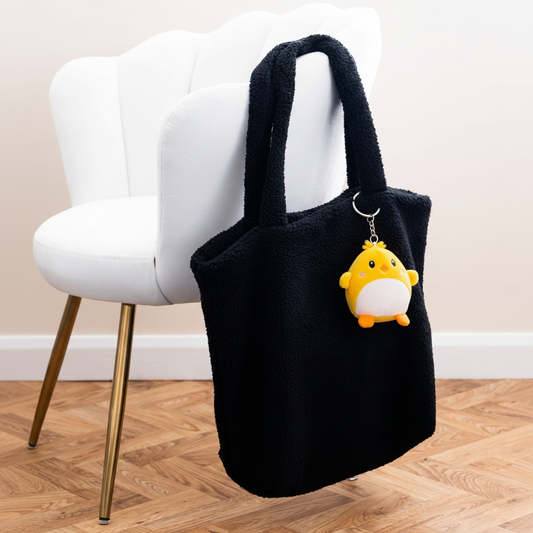 Mumbles Character Keyring on black fleece shopper with white velvet chair